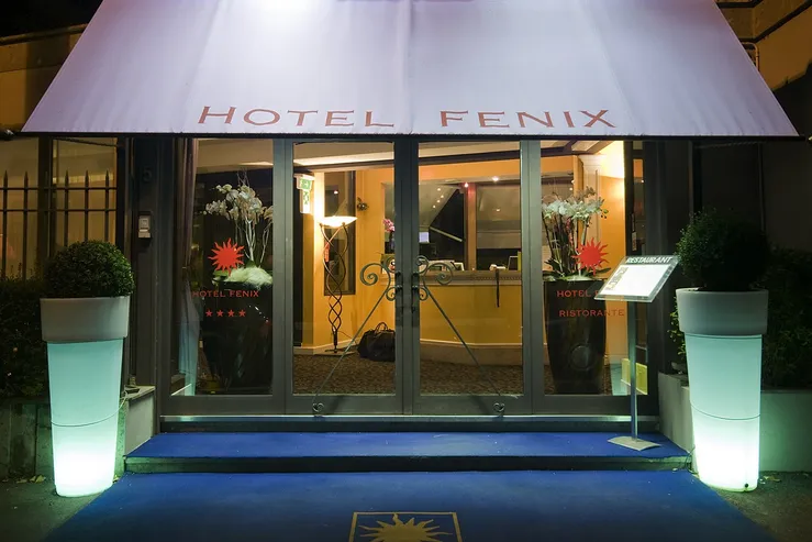 L'ingresso dell'Hotel Fenix Roma di sera, con la reception e il servizio concierge