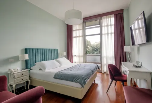 Camera Doppia Classic del Fenix Hotel Roma con letto matrimoniale e vista sul verde