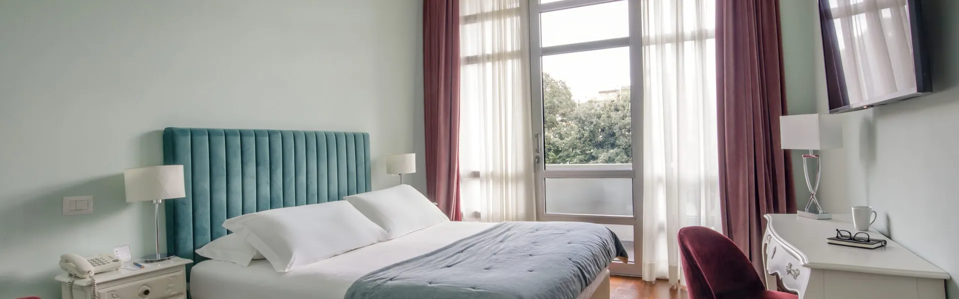 Camera Doppia Classic del Fenix Hotel Roma con letto matrimoniale e vista sul verde