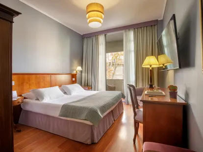 Letto matrimoniale e scrittoio della camera Doppia Executive