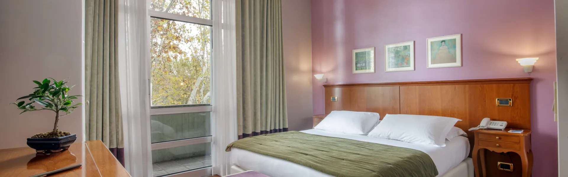 Camera Doppia Executive del Fenix Hotel Roma con letto matrimoniale e ampie vetrate sul verde