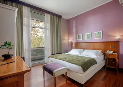 Camera Doppia Executive del Fenix Hotel Roma con letto matrimoniale e ampie vetrate sul verde