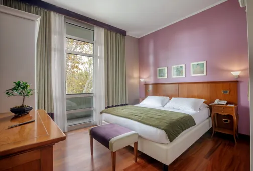 Camera Doppia Executive del Fenix Hotel Roma con letto matrimoniale e ampie vetrate sul verde