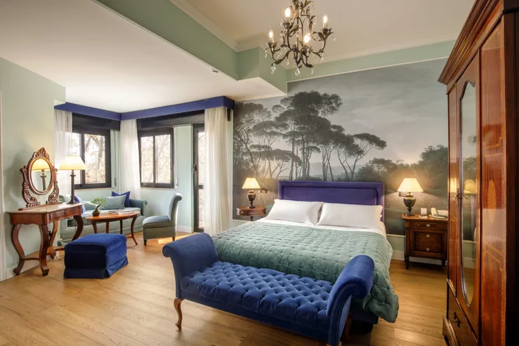 Camera Doppia Superior del Fenix Hotel Roma con carta da parati a pini, letto matrimoniale e dormeuse in velluto blu