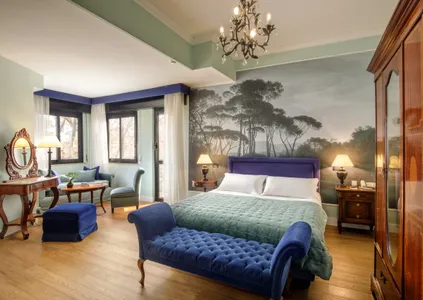 Camera Doppia Superior del Fenix Hotel Roma con carta da parati a pini, letto matrimoniale e dormeuse in velluto blu