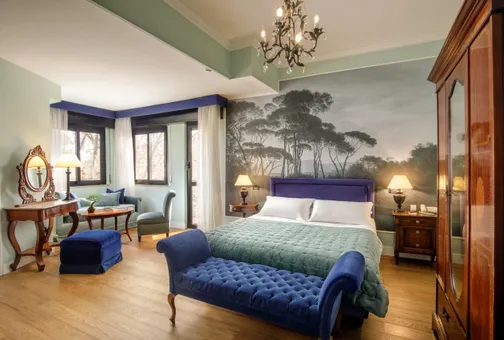 Camera Doppia Superior del Fenix Hotel Roma con carta da parati a pini, letto matrimoniale e dormeuse in velluto blu