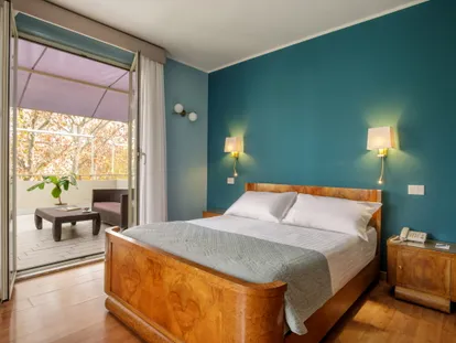 Camera Doppia Superior con letto in legno e porta-finestra sul terrazzino