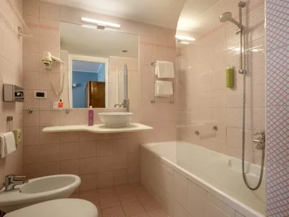 Bagno con vasca e doccia in una camera Doppia Superior