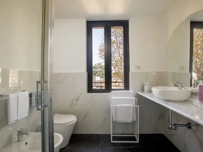 Bagno bianco con doccia e lavabo da appoggio in una camera Doppia Superior