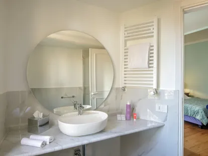 Lavabo con specchio rotondo in una camera Doppia Superior