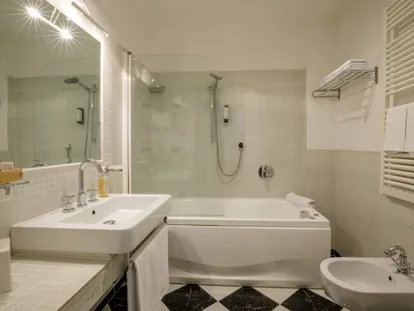 Bagno della Junior Suite con vasca, doccia e pavimento a scacchi