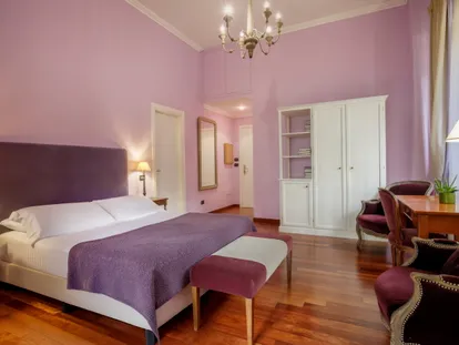 Letto matrimoniale e armadio della Junior Suite nei toni del viola