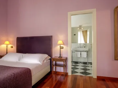 Letto matrimoniale e ingresso al bagno della Junior Suite