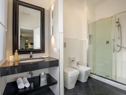Bagno della Junior Suite con doccia in cristallo e piano lavabo scuro