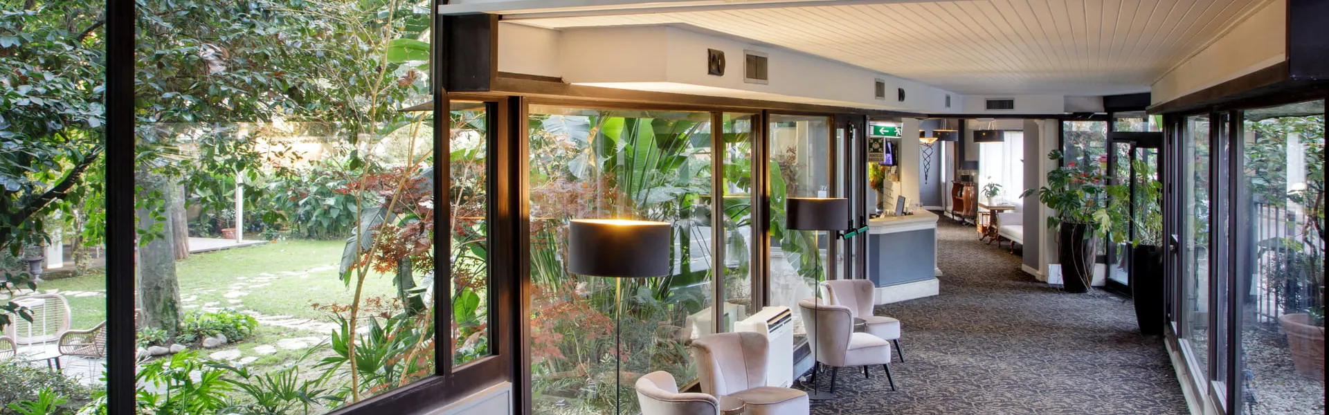 Il salone vetrato del Fenix Hotel Roma affacciato sul giardino