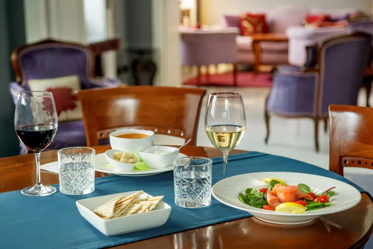 Tavola apparecchiata nel ristorante del Fenix Hotel Roma, con vino e piatti della cucina mediterranea